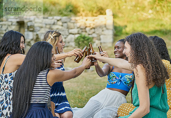 Gruppe von Freundinnen trinken Bier in einem Park an einem Sommertag