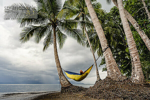 Erwachsener entspannt sich in Hängematte am Strand in Costa Rica