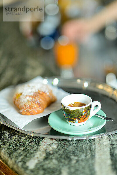 Espresso-Kaffee und Vanillepudding-Croissant für einen kalorischen