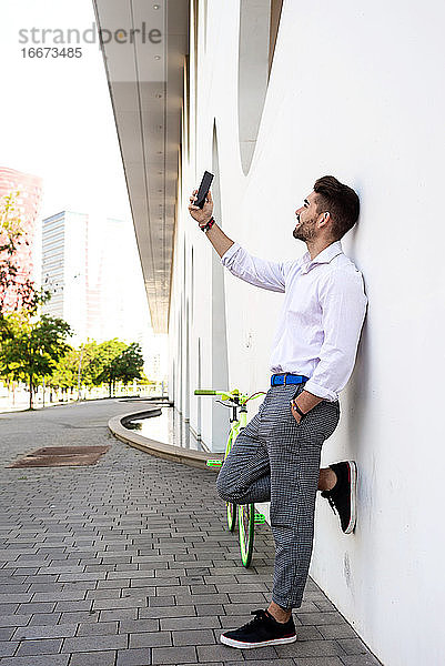 Porträt von stilvollen gut aussehend jungen jungen Mann  der selfies mit Telefon