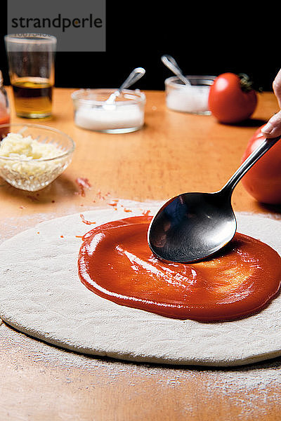 Tomaten auf einen selbstgemachten Pizzaboden gießen und im Ofen zubereiten