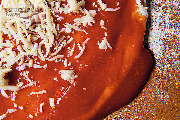 Bei der Zubereitung des Pizzabodens zu Hause legen wir Tomaten  Käse ...