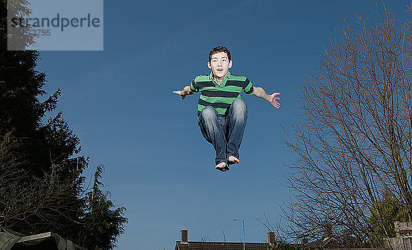 Junge springt auf Trampolin in Woking - England