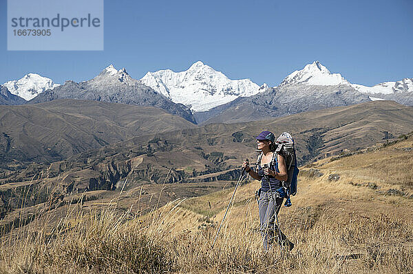 Eine Frau mit Rucksack beim Wandern in Huaraz mit Cordillera Blanca