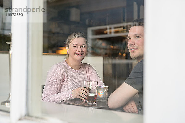 Reisendes Paar genießt heißen Tee in einem Café