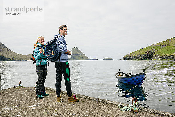 Glückliche Touristen stehen am Kai in der Nähe des Schiffes