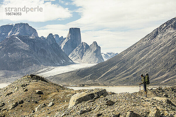 Rucksacktourist in zerklüfteter Landschaft mit Blick auf die Berge.