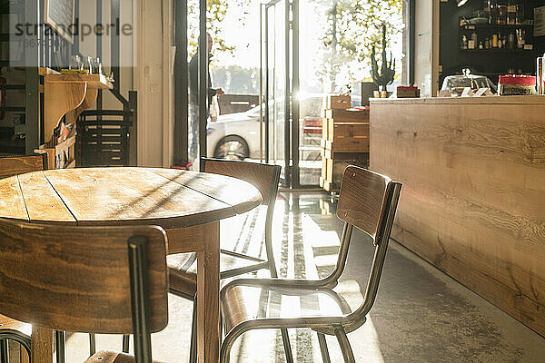 Holztisch in einem leeren Cafe in Toulouse an einem sonnigen Tag niemand