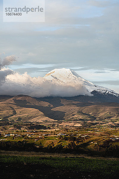 Cayambe Berg Nahaufnahme mit Sonnenlicht und Stadt