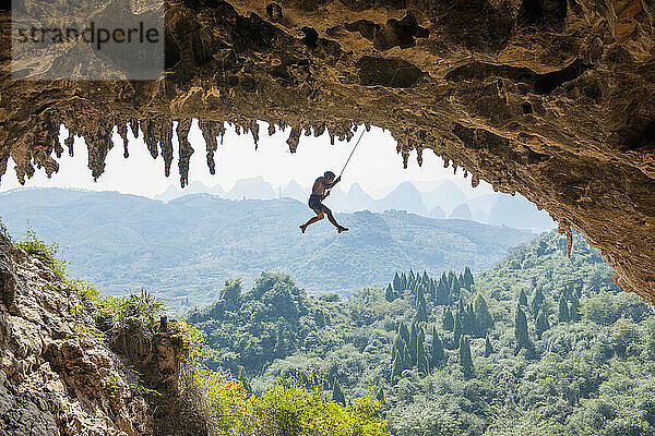 Mann beim Klettern in Odin's Den in Yangshuo  einem Klettermekka in China