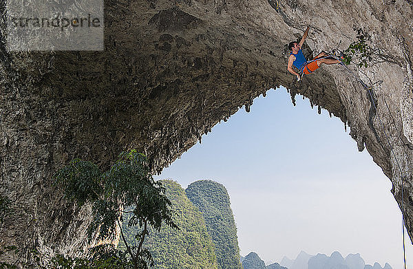 Mann beim Klettern auf dem Mondberg in Yangshuo  einem Klettermekka in China
