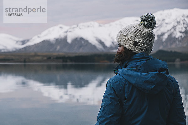 Junge Frau mit Blick auf die Spiegelung der Südalpen über dem Lake Tekapo