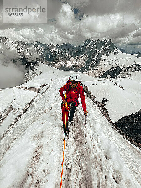 Junge Bergsteigerin auf schmalem Schneegrat oberhalb der Gletscher des Mt. Blanc