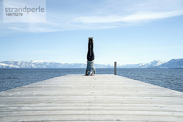 Frau macht einen Kopfstand am Ende eines Piers in South Lake Tahoe  CA