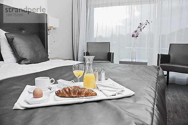 Frühstückstablett auf einem Bett in einem Luxushotelzimmer