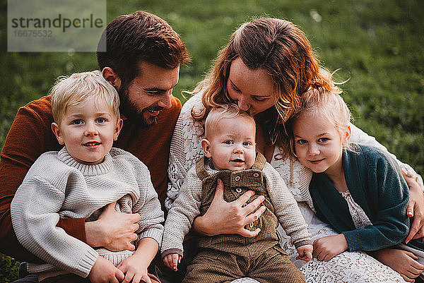 Schöne Familie sitzt im Park an einem Herbsttag