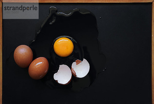 Zerbrochenes Ei auf dem schwarzen Boden