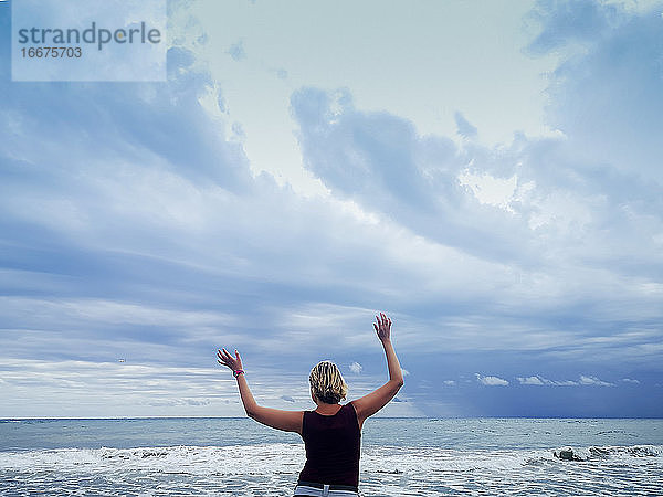 attraktive blonde Frau genießt den Strand an einem bewölkten Tag