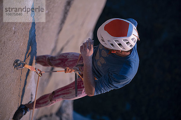 Bergsteiger mit Helm  der an der Wand hängt  während er die schwierige Route El Capitan versucht