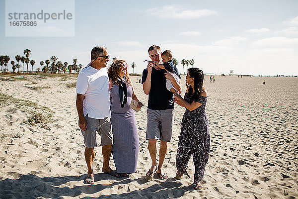 Fünfköpfige Familie beim Spaziergang am Strand