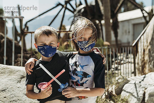 Close up Porträt von jungen Brüdern mit Masken auf draußen im Urlaub