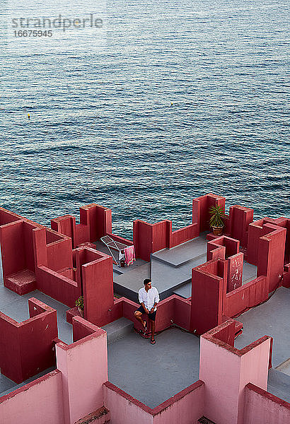 Junger lateinamerikanischer Mann meditativ in 'Muralla Roja' aus Calpe  Spanien