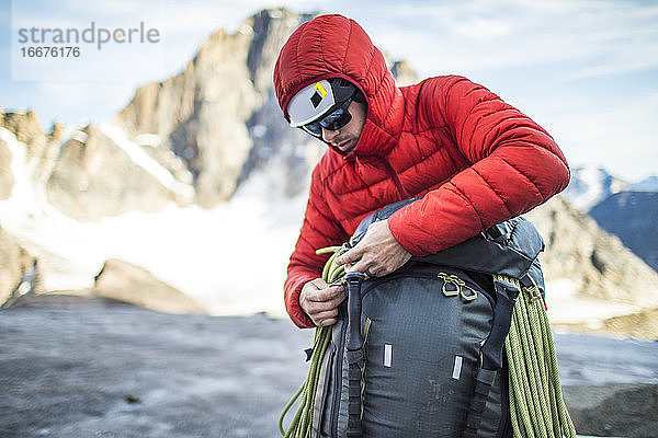 Bergsteiger packt seinen Rucksack nach einer erfolgreichen Besteigung.