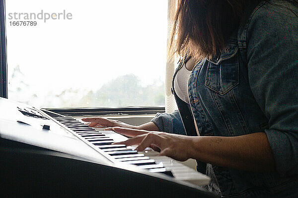 Mädchen spielt Klavier mit Händen in Großaufnahme
