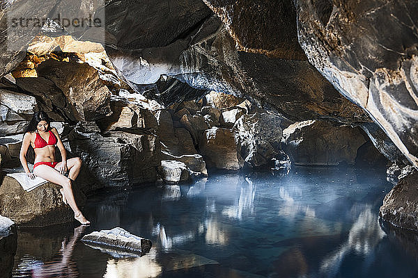 Frau in der Grjotgja-Höhle im Norden von Island