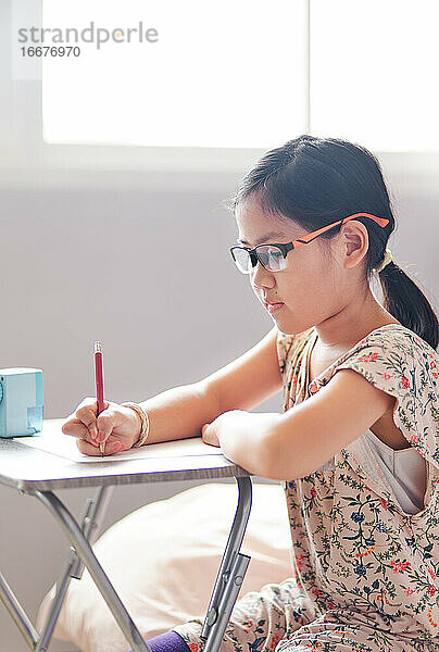 Das Mädchen konzentriert sich während der Heimschule auf ihre Arbeit