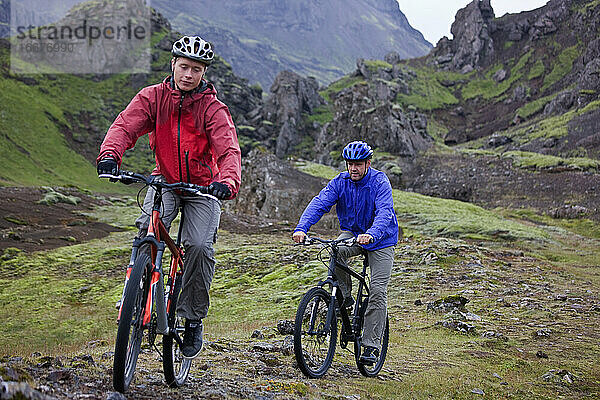 zwei Freunde fahren mit ihren Mountainbikes um den Thingvellir-See