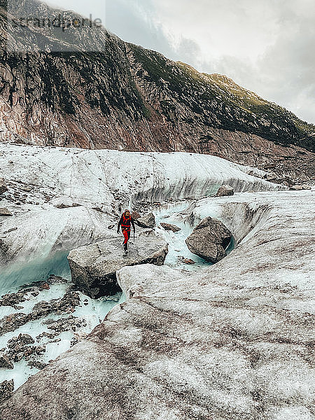 Junge Bergsteigerin bei der Flussüberquerung auf dem Gletscher Mer de Glace