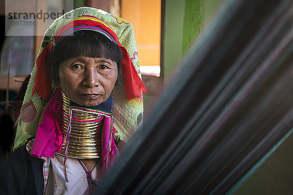 Porträt einer älteren birmanischen Frau vom Stamm der Kayan beim Weben in einer Textilwerkstatt  Inle-See  Myanmar