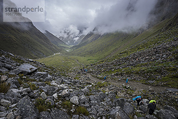 Wanderer beim Aufstieg durch das Tal auf dem Salkantay-Pfad zum Salkantay-Pass bei nebligem Wetter  Peru