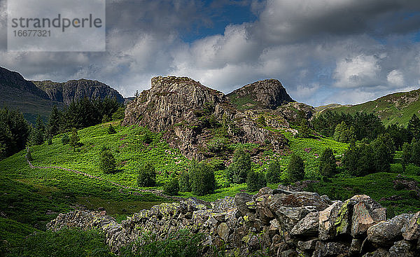 Ein Blick auf eine traditionelle Steinmauer führt hinunter zu einem kleinen Felsvorsprung auf Blea Moss in der Nähe von Blea Tarn