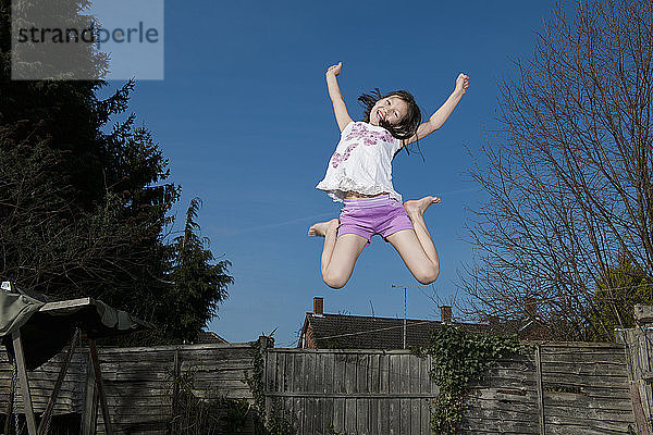 junges Mädchen springt auf einem Trampolin in Woking - England