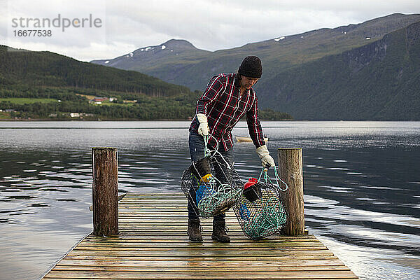 Ein Fischer sammelt seine Krabbenreusen an einem Fjord in Norwegen ein