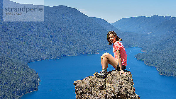 Wanderer Mädchen ist auf der Spitze des Berges mit Blick auf tiefblauen See