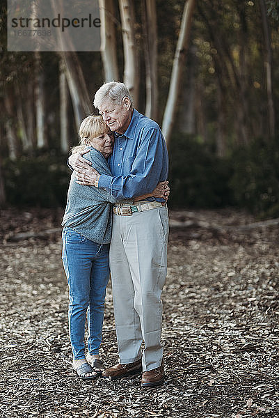 Porträt eines älteren Paares im Ruhestand  das sich im Wald umarmt