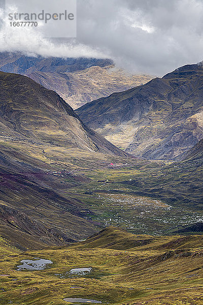 Panoramablick auf ein Tal inmitten hoher Andenberge auf dem Rainbow Mountain Trail  Pitumarca  Peru