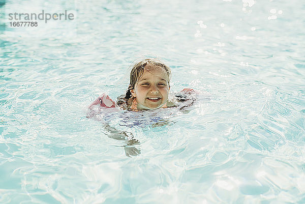 Junges Mädchen im Vorschulalter schwimmt im Pool im Urlaub in Palm Springs