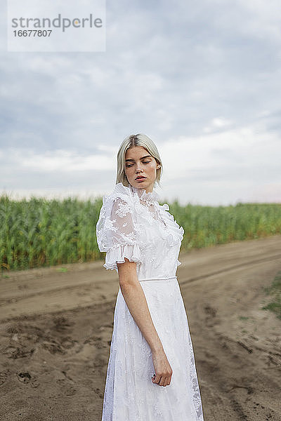 Frau im weißen Kleid geht in der Natur spazieren