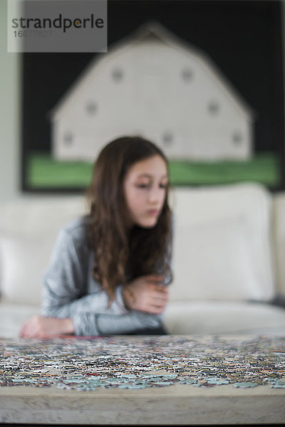 Mädchen spielt mit Puzzle im Inneren