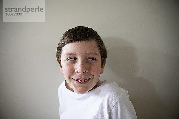 Close Up Porträt von Tween Junge mit Zahnspange Lächeln Blick aus der Kamera