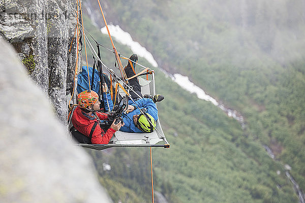 Felskletterer ruhen sich während einer mehrtägigen Klettertour auf einem Portaledge aus.