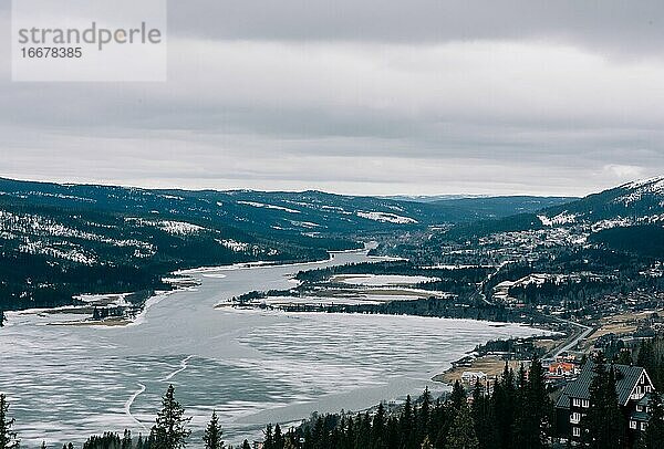 Blick über einen schneebedeckten See und Berge in Nordschweden