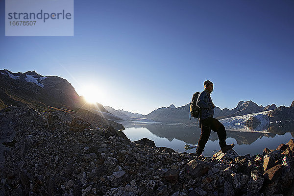 Mann beim Wandern an einem Fjord in Ostgrönland