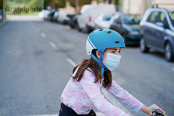 Mädchen mit Maske fährt Kick-Scooter