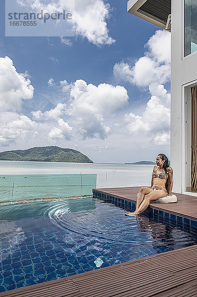 schöne Frau am Pool einer Luxusvilla in Phuket