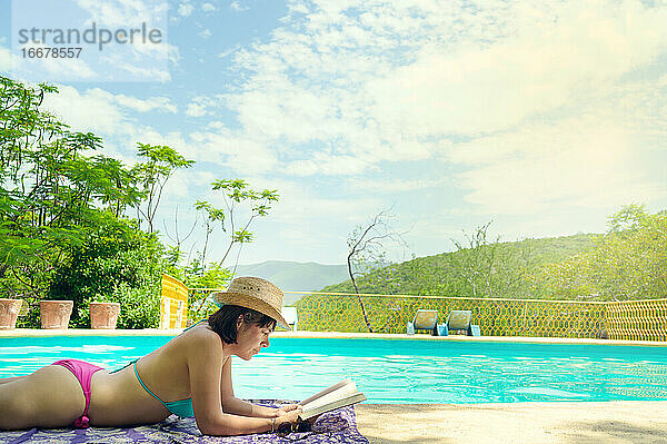 Frau beim Lesen und Entspannen im Luxus-Swimmingpool. Entspannender Urlaub